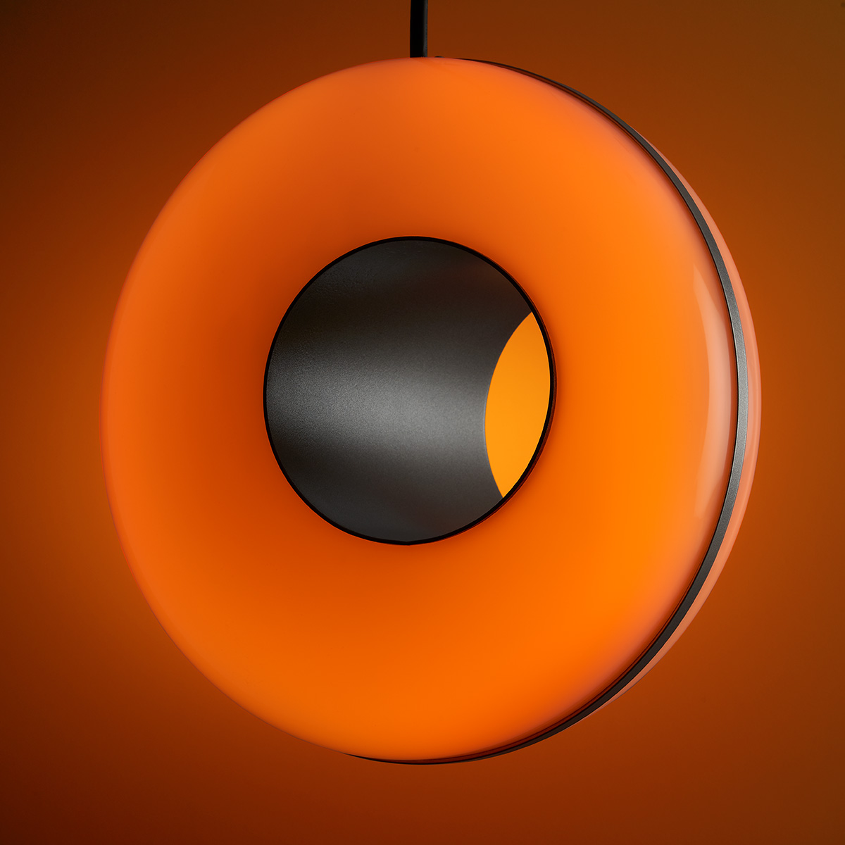 RGB pendant light with orange light and circle cut out. 