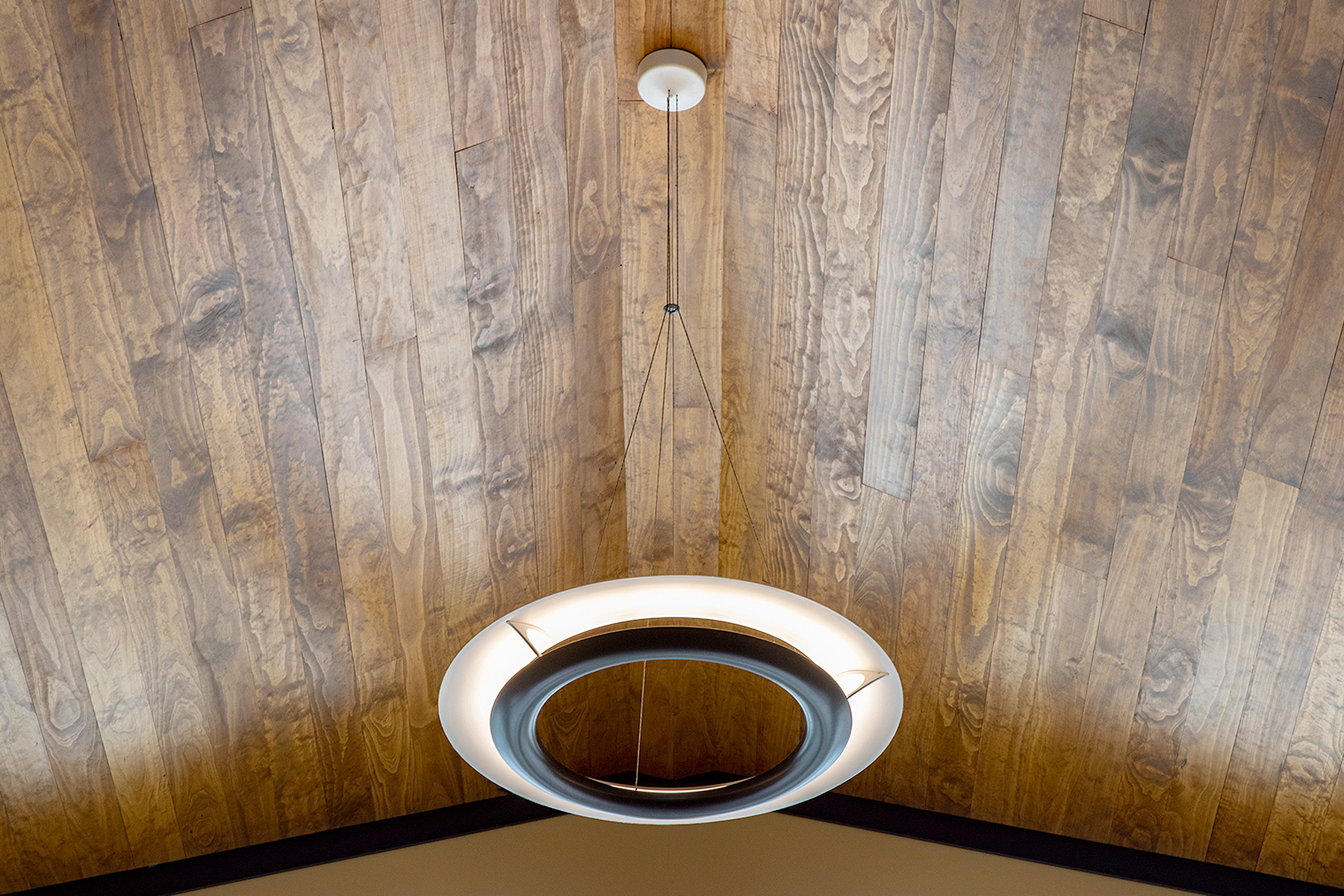 Cosmo Light hanging from tall wooden ceiling 