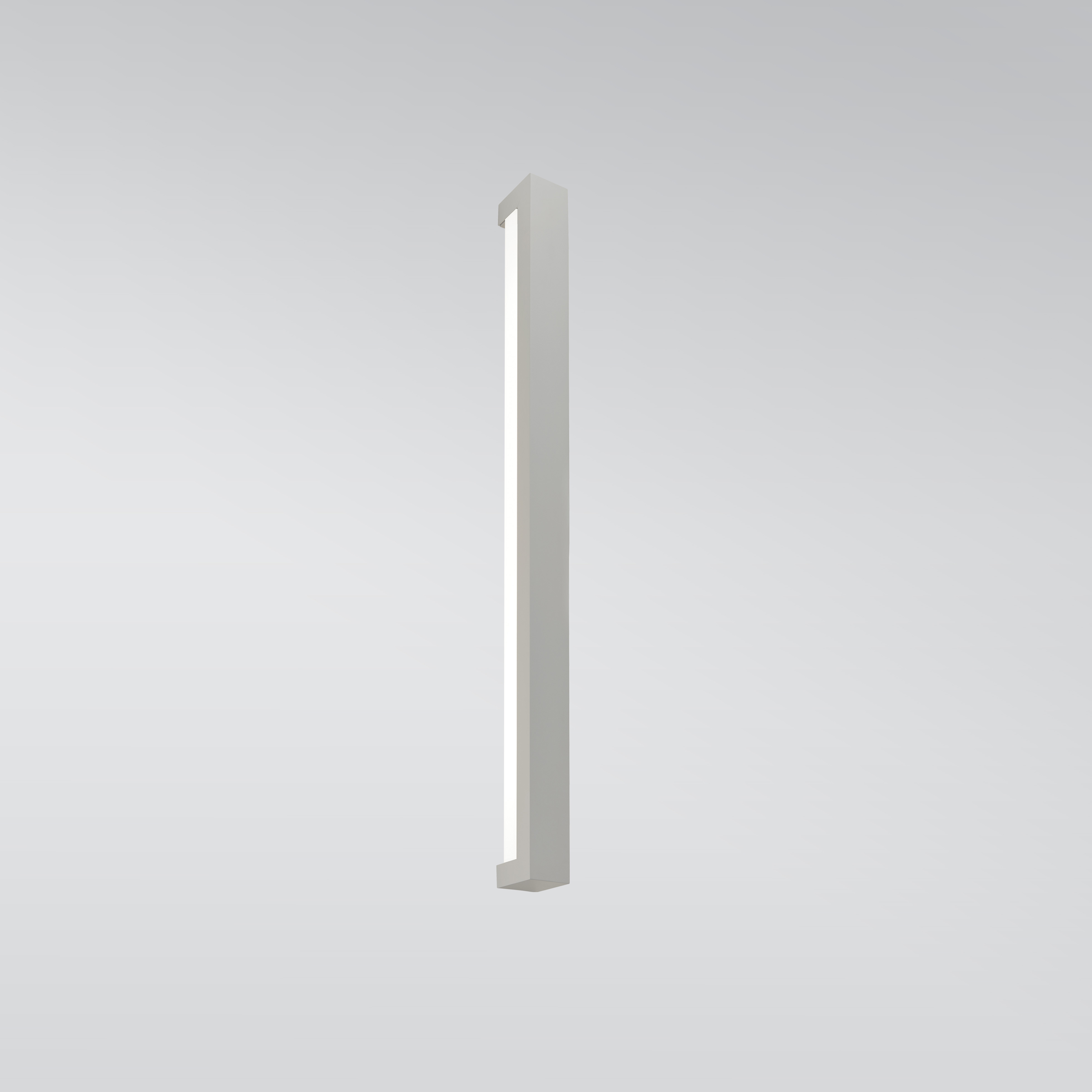 A linear wall sconce with a solid outer body and a luminous diffuser underneath