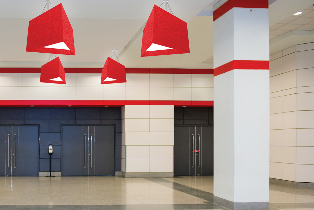 Large red triangle acoustic light mounted in school gym education space. 