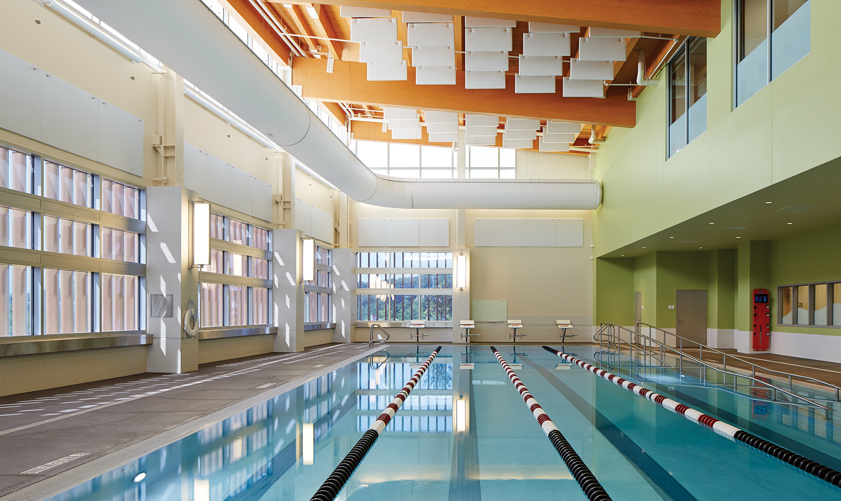 Air Foil sconces showing off modern lighting design along a well-lit indoor pool.