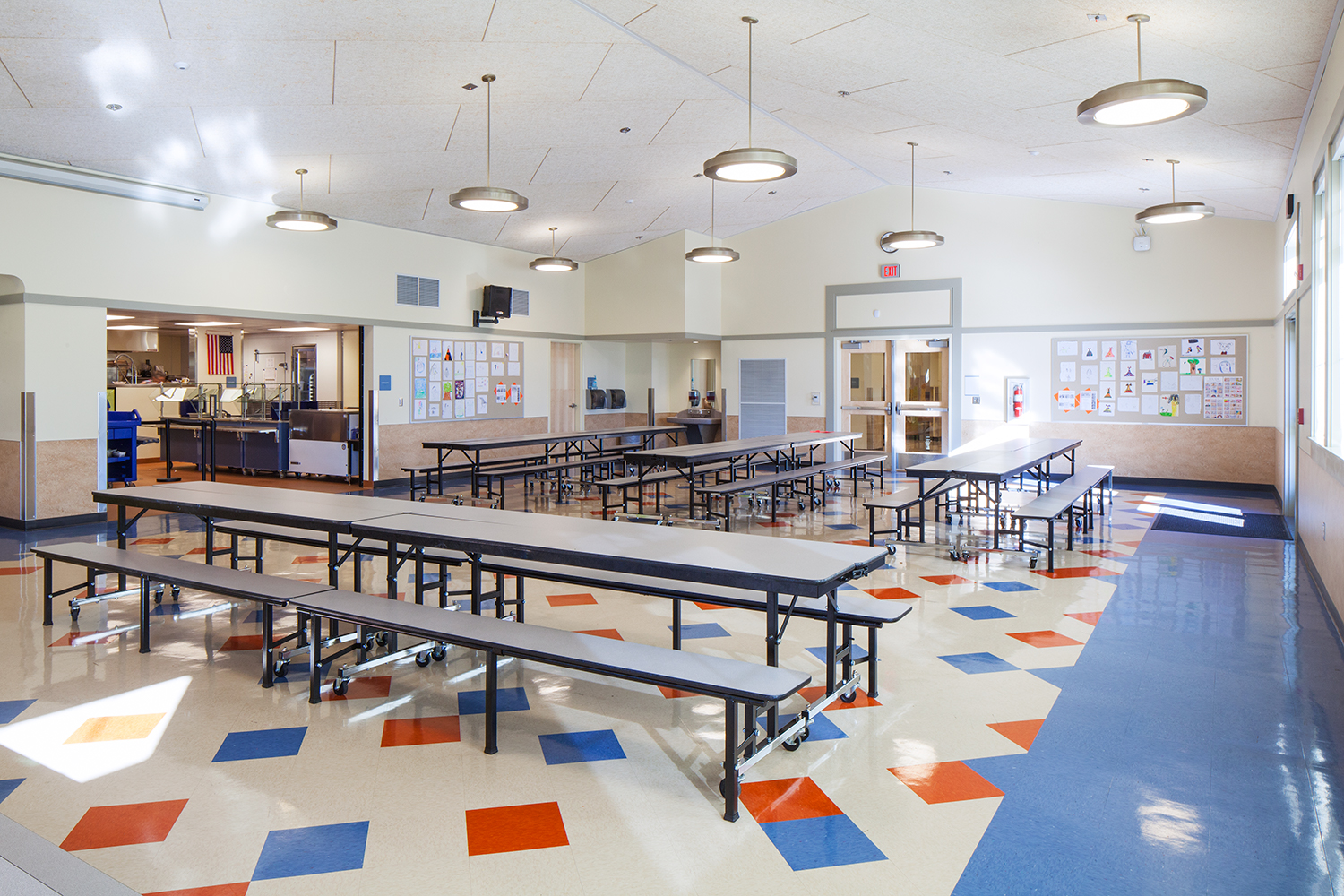 Broadway pendant luminaires as classroom lighting, hung over tables in a school cafeteria.