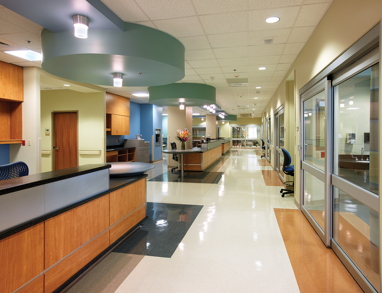 Cane ceiling luminaires in a clean hospital design illuminate a nurse's station.
