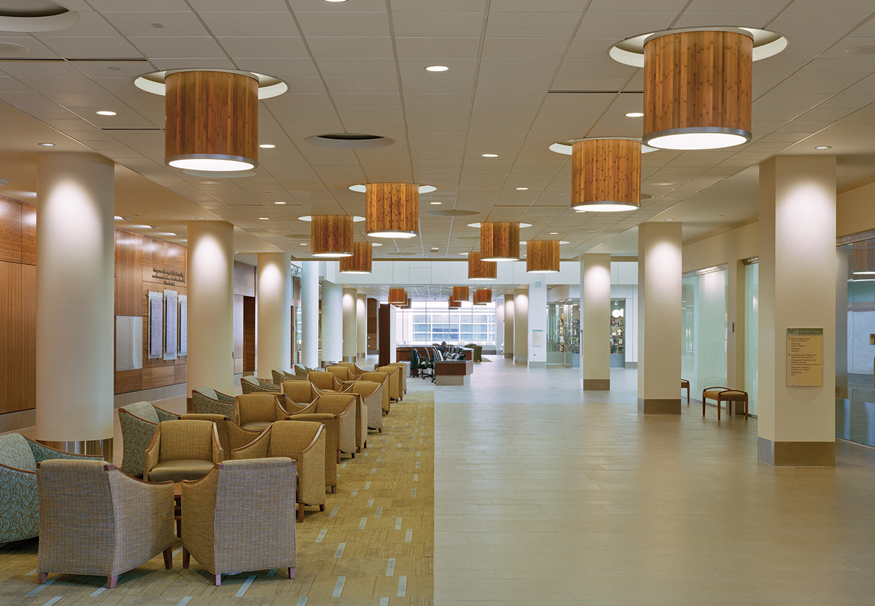 Large, wood-paneled custom light fixtures mounted above a warm waiting room.