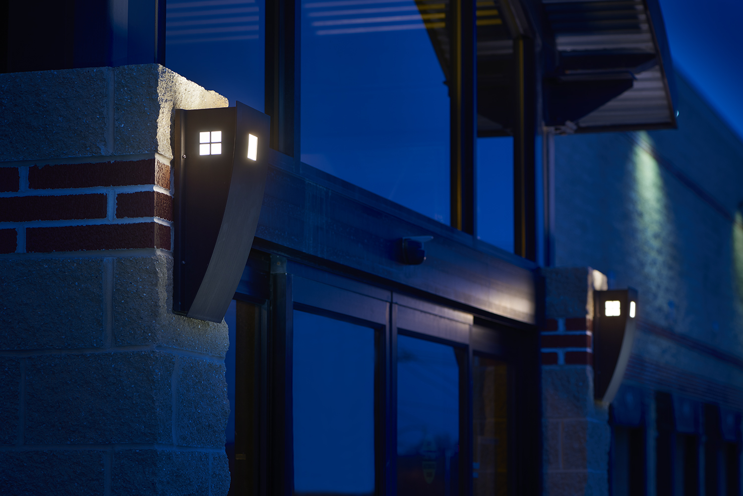 Cypress outdoor light fixture illuminates a dark exterior doorway, with small window cutouts on the side of the luminaire body.