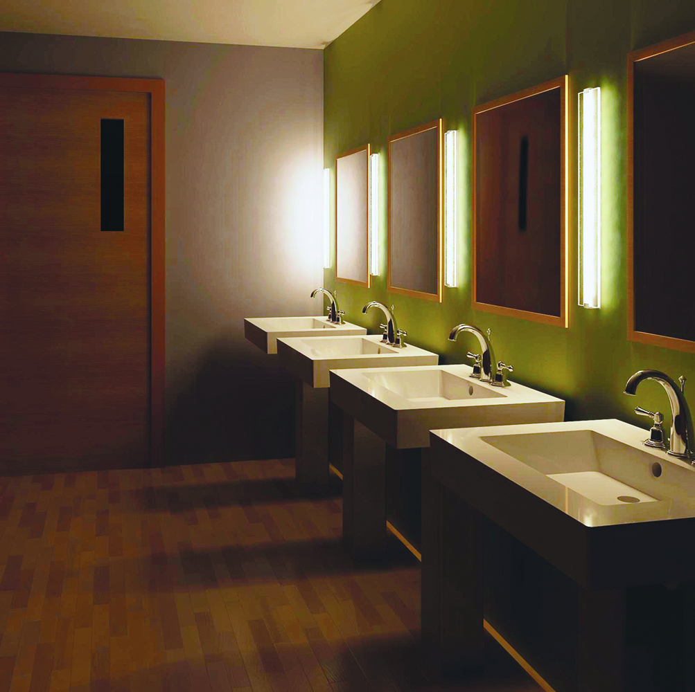 Deck as a modern vanity light fixture, mounted vertically between mirrors in a public restroom