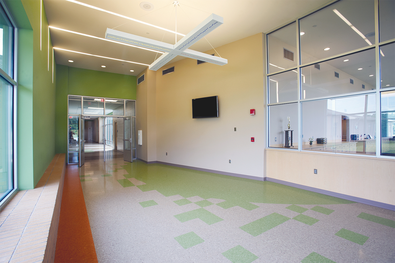 Infinity Performance configurable pendant in educational interior design above school hallway.