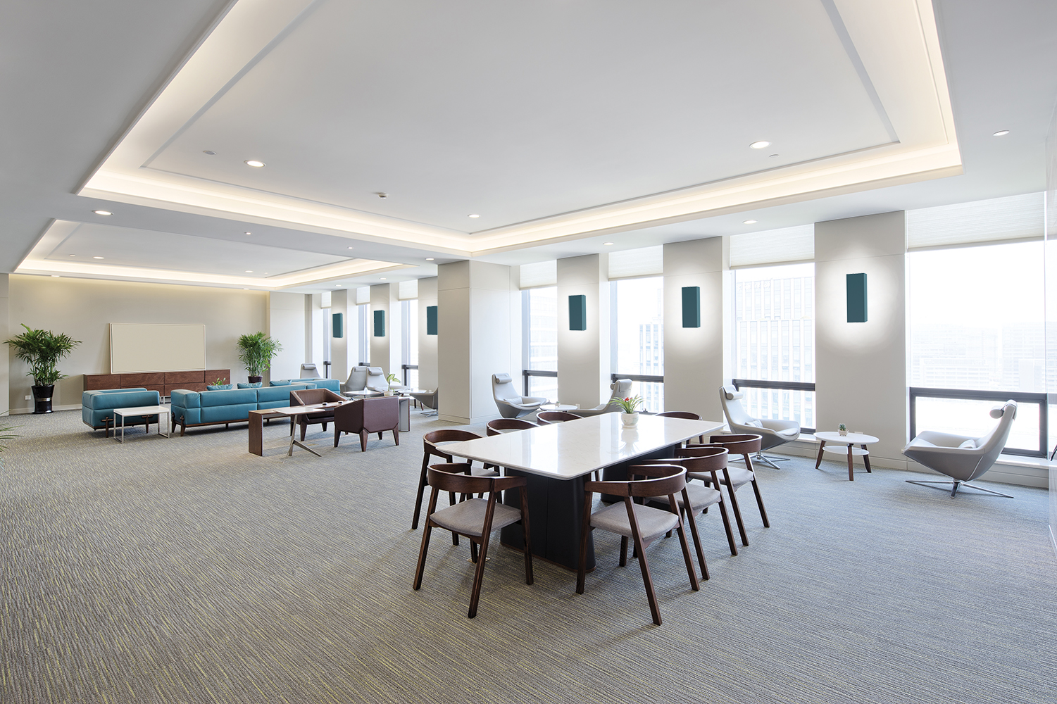 Shield sconces provide attractive indirect light in a large meeting room area for relaxing office lighting design.