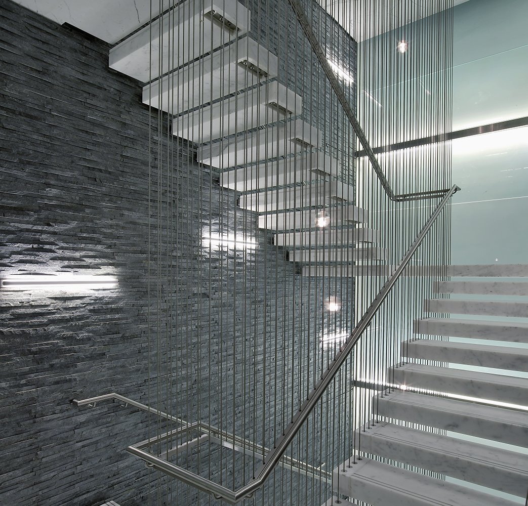 Sleight office lighting illuminating an ultra-modern textured stairwell wall.