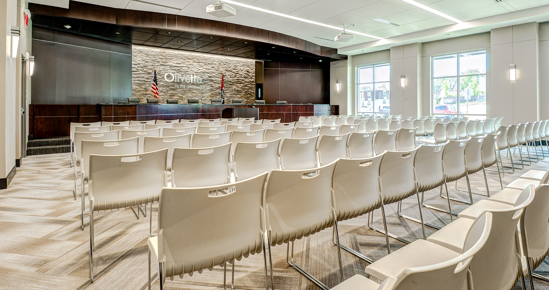 Wedge sconces provide sophisticated architectural lighting for a modern town meeting hall 