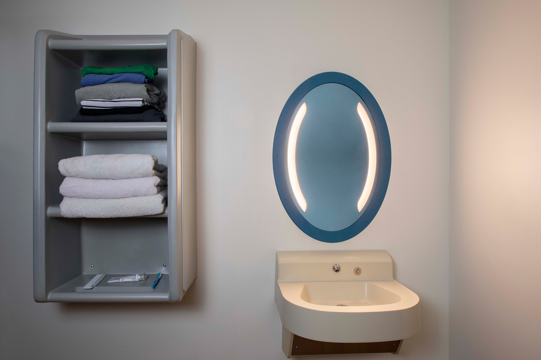 Sole oval illuminated mirror in a behavioral health bathroom
